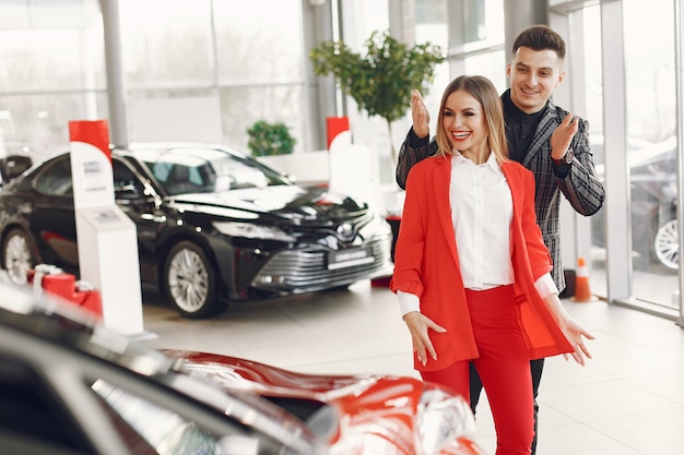 Stylish and elegant couple in a car salon