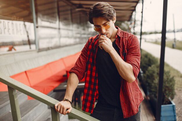 Stylish and elegant man in a city with vape