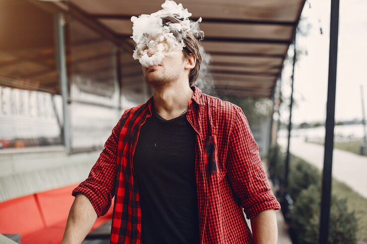 Stylish and elegant man in a city with vape