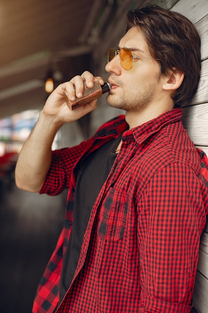 Uomo elegante e alla moda in una città con vaporizzatore