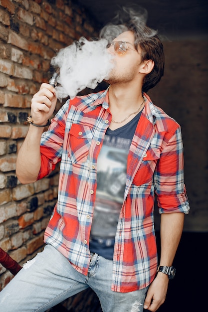 Free photo stylish and elegant man in a city with vape