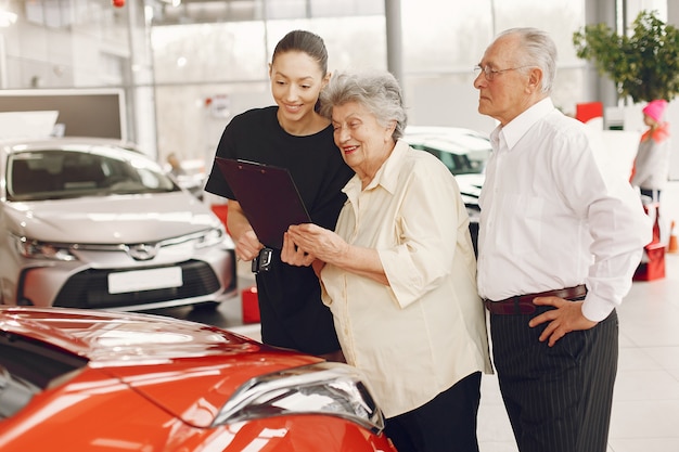 Stylish and elegant old couple in a car salon