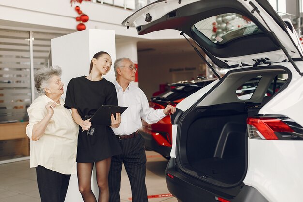 Stylish and elegant old couple in a car salon