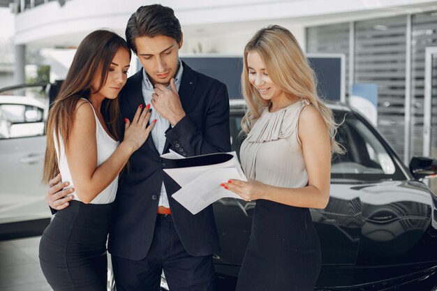 Stylish and elegant people in a car salon