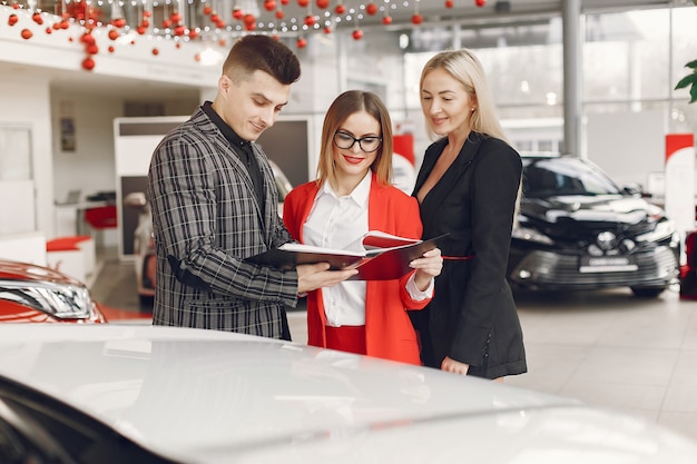 Stylish and elegant people in a car salon