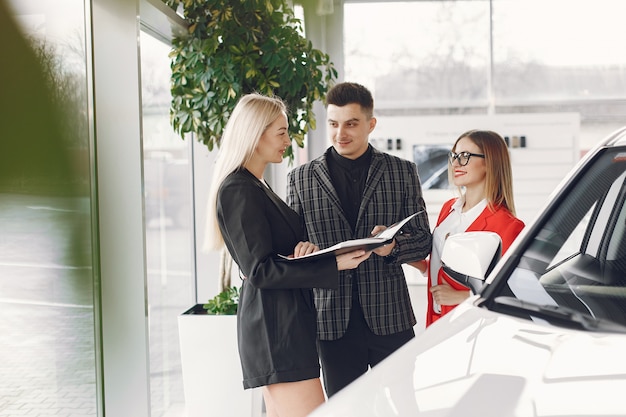 Stylish and elegant people in a car salon