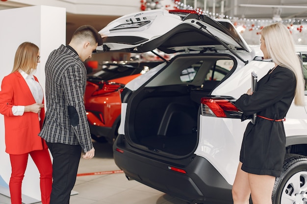 Persone eleganti e alla moda in un salone d'auto