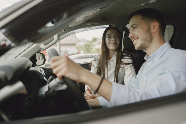 Stylish and elegant people in a car salon