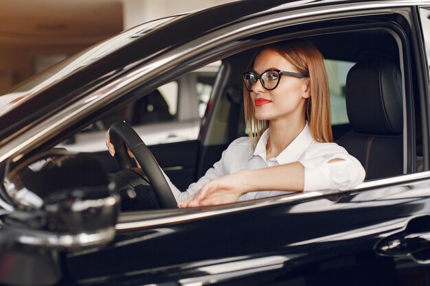 車のサロンでスタイリッシュでエレガントな女性