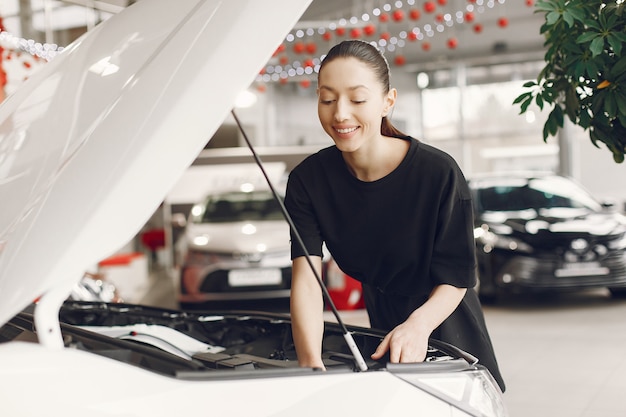 Donna elegante e alla moda in un salone di auto