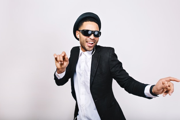 Stylish excited guy in suit, hat, black sunglasses having fun. Leisure, weekends, cheerful mood, joy, happiness, dancer, singing, modern businessman, isolated.