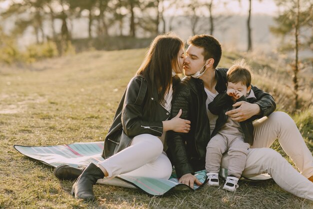 Famiglia alla moda che si siede su un giacimento della molla