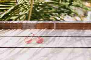 Free photo stylish female glasses lying on wooden table.