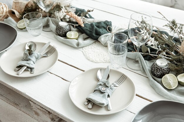 Стильная праздничная сервировка стола с деталями скандинавского декора на деревянной поверхности.