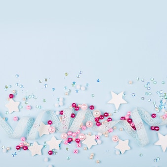 Стильная рамка с милым украшением: кружевная лента, звезды, блестки и розовые жемчужные бусины с копией пространства для текста на синем фоне. плоская планировка, вид сверху