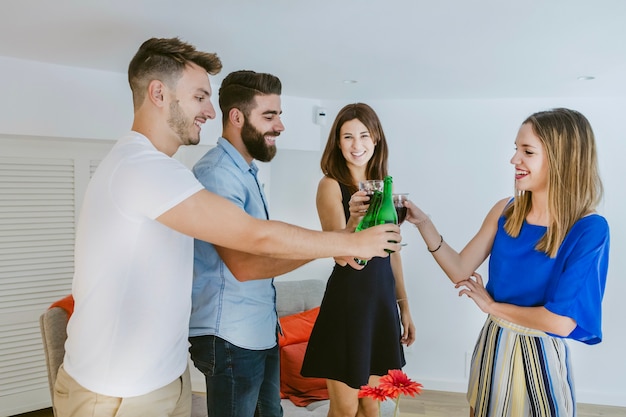 Stylish friends clinking with drinks