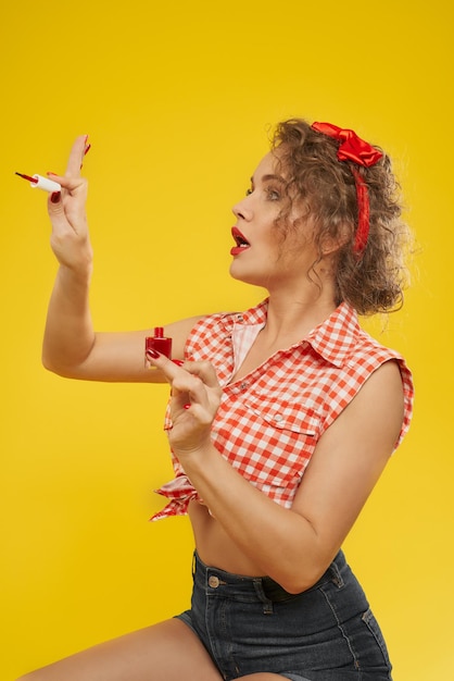 Stylish girl looks satisfied with new selfmade manicure