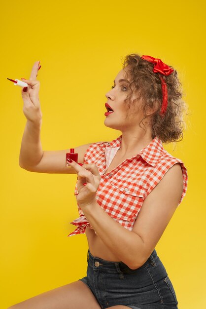 Stylish girl looks satisfied with new selfmade manicure