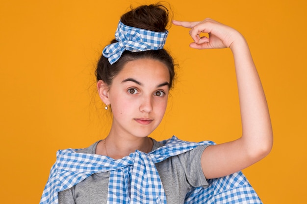 Free photo stylish girl pointing to her bun