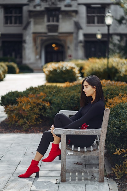 stylish girl sitting on a bench at school