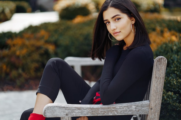 Stylish girl sitting on a bench at school