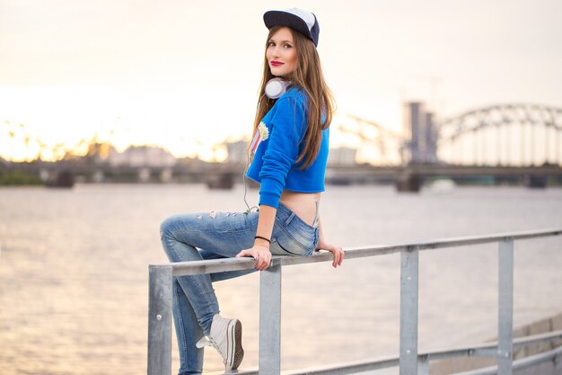 Stylish girl sitting on a handrail