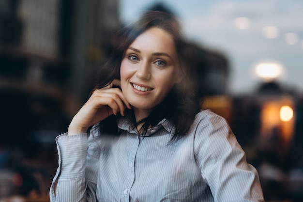 La ragazza alla moda che si siede al ristorante