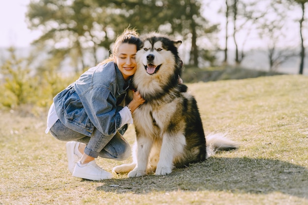 犬と日当たりの良いフィールドでスタイリッシュな女の子