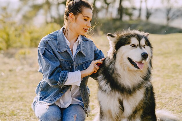 犬と日当たりの良いフィールドでスタイリッシュな女の子