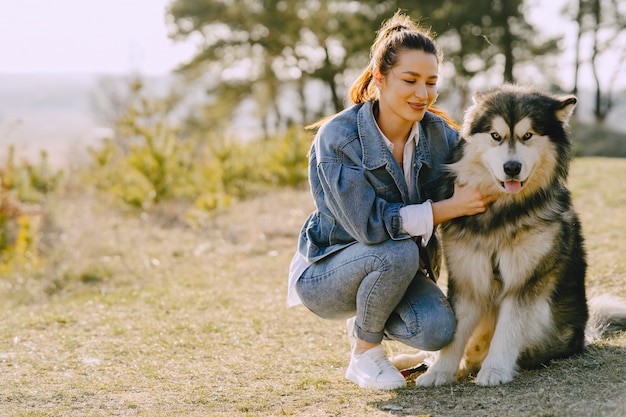 犬と日当たりの良いフィールドでスタイリッシュな女の子