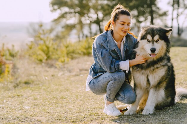 犬と日当たりの良いフィールドでスタイリッシュな女の子