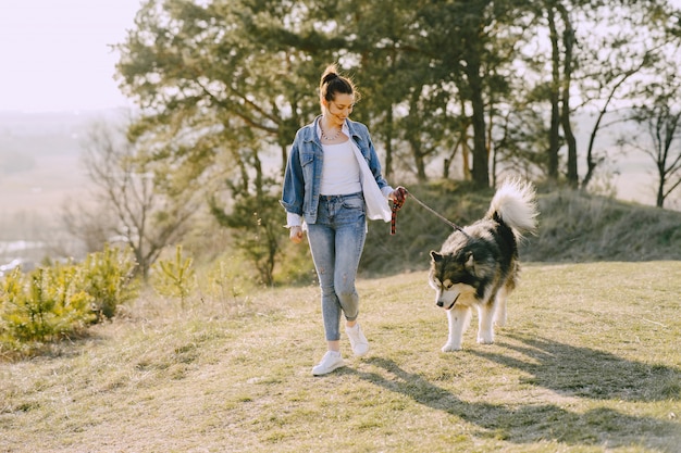 犬と日当たりの良いフィールドでスタイリッシュな女の子