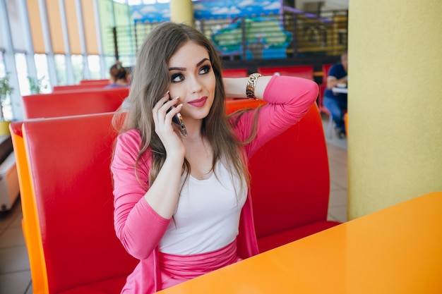 Foto gratuita elegante ragazza parla al telefono e alzando lo sguardo