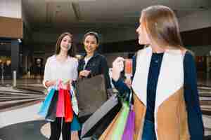 Free photo stylish girls posing in shopping center