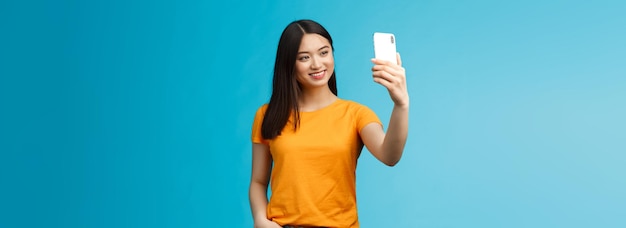 Elegante bella ragazza asiatica carina tenere smartphone parlando videochiamata sorridente ampiamente guardare telefono scr