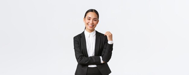 고객에게 집을 판매하는 세련된 여성 중개인 흰색 배경에서 행복하고 자신감 넘치는 성공적인 관리자로 웃고 있는 소송에서 아시아 여성 사업가
