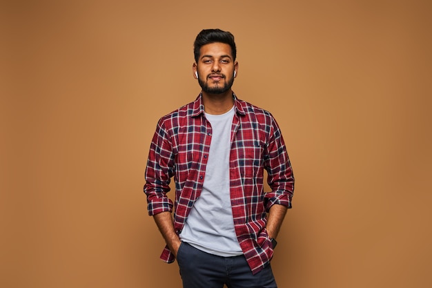 Stylish handsome indian man in tshirt on pastel wall
