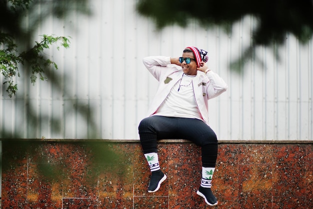 Стильный хипстерский арабский парень позирует на улице в стиле рэп-певца