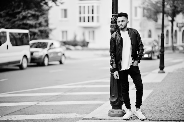 Stylish indian beard man at black leather jacket India model posed outdoor at streets of city