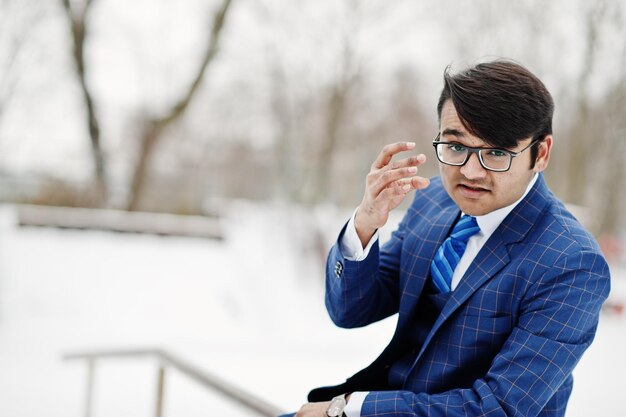 Stylish indian business man in suit and glasses posed at winter day outdoor