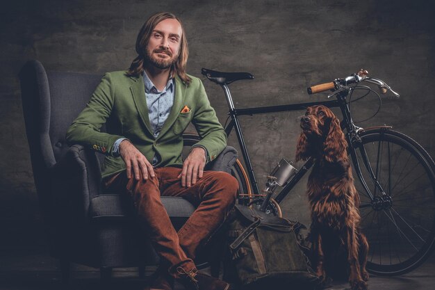 シングルスピード自転車とアイリッシュセッター犬でポーズをとるスタイリッシュなアイルランドの流行に敏感な男。