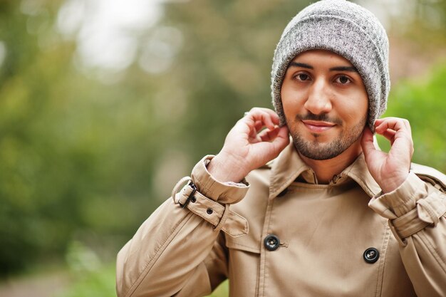 Stylish kuwaiti man at trench coat and hat