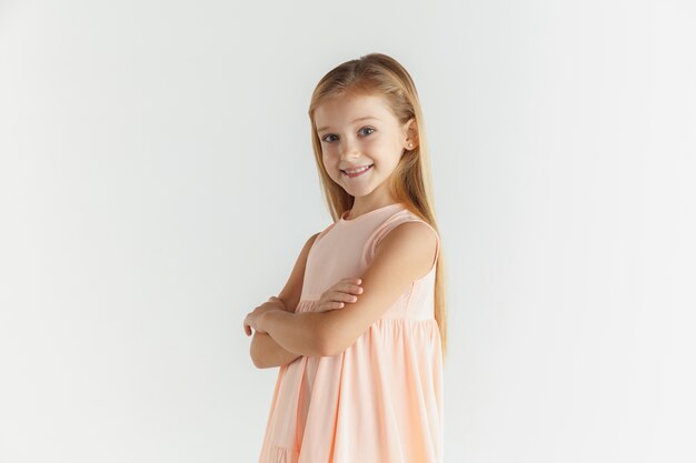 Stylish little smiling girl posing in dress isolated on white studio