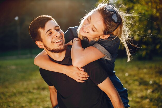 Stylish loving couple standing in a park. 