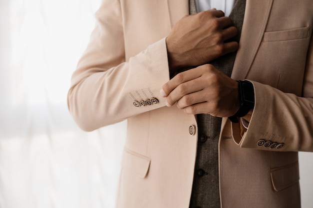 Stylish man adjusts a sleeve of his jacket