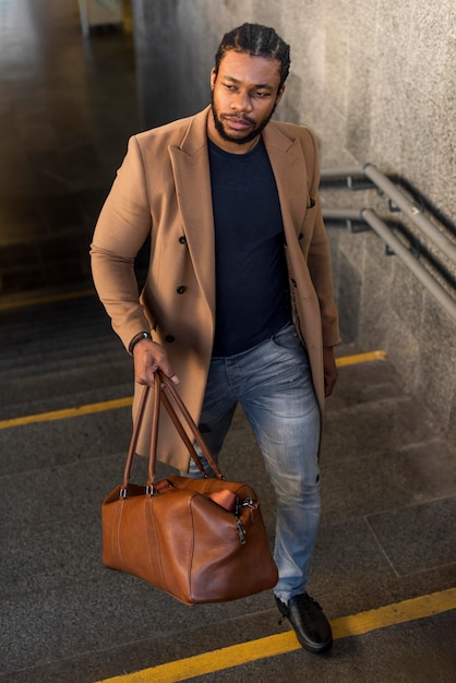 Stylish man holding a leather bag