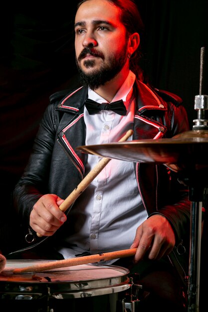 Stylish man playing on drum set