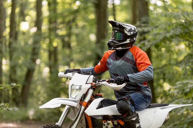 Stylish man riding motorbike in the forrest