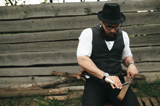 Stylish man sharpening a razor