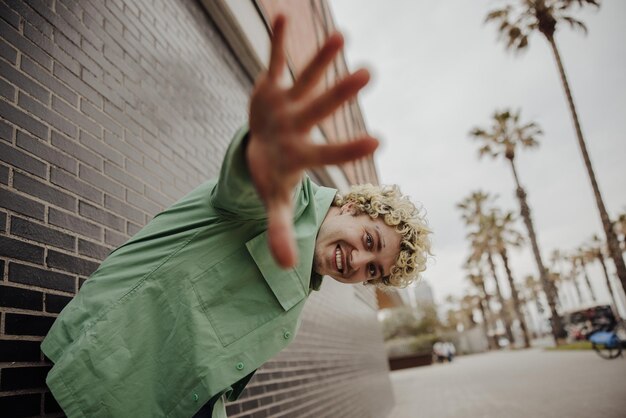 Stylish man shows a hand to camera